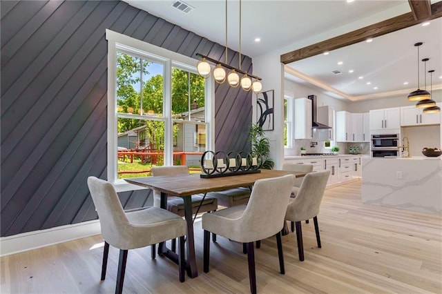 dining space with light wood finished floors and recessed lighting