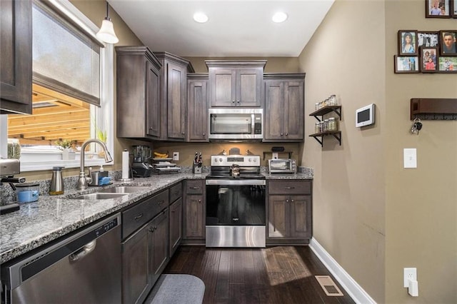 kitchen with a sink, dark brown cabinets, appliances with stainless steel finishes, and visible vents