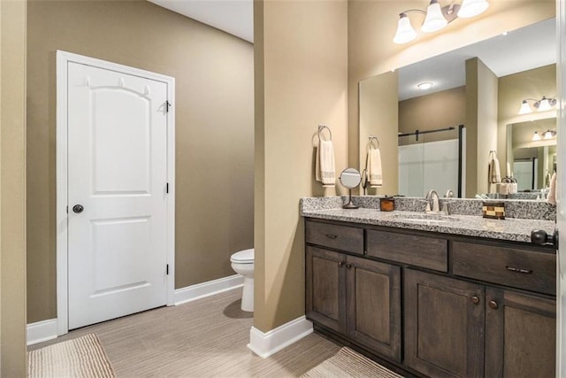 full bath featuring vanity, baseboards, toilet, and a shower