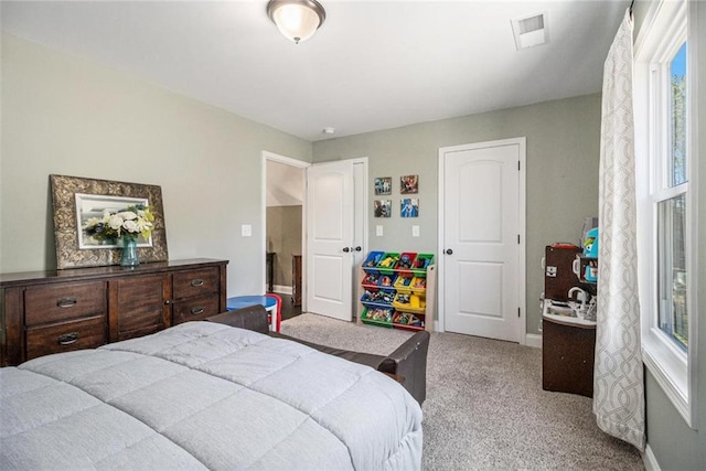 bedroom with baseboards, visible vents, and light colored carpet