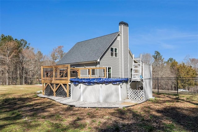 back of property featuring fence, a chimney, a fenced in pool, and stairway