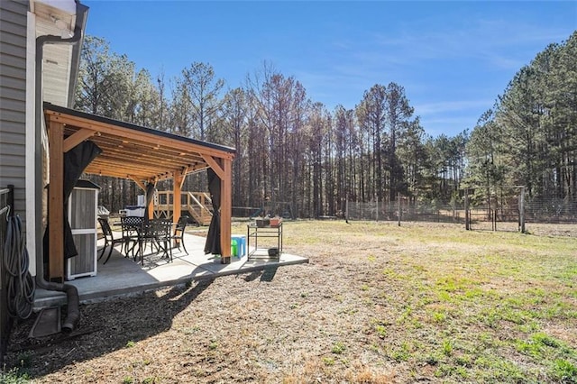 view of yard with fence, a patio area, and a storage shed