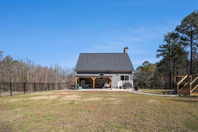 back of house with a fenced backyard, a lawn, and a deck