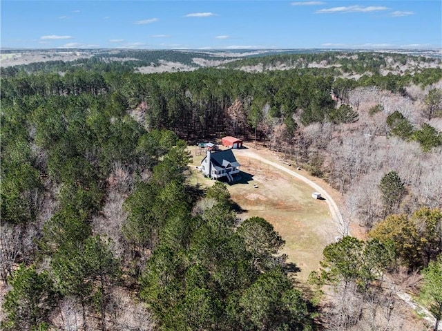 bird's eye view with a wooded view