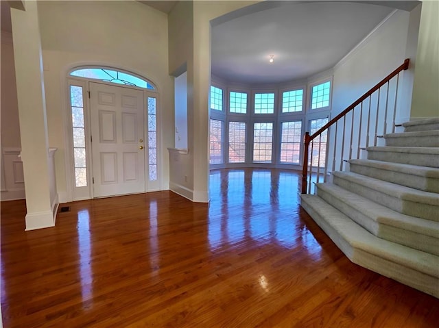 foyer with a wealth of natural light, stairway, baseboards, and wood finished floors