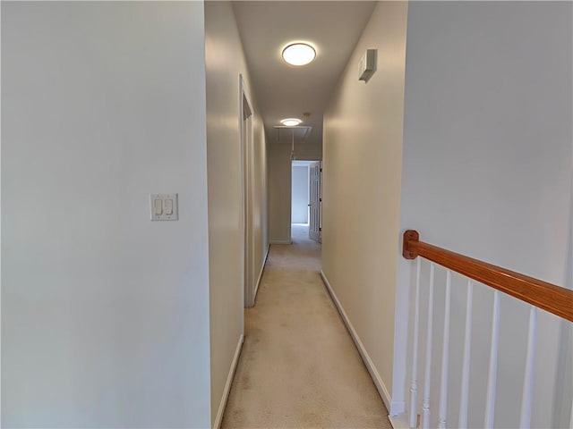 hall featuring light carpet and baseboards