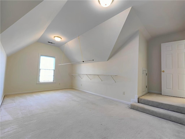 additional living space featuring light carpet, baseboards, visible vents, and vaulted ceiling