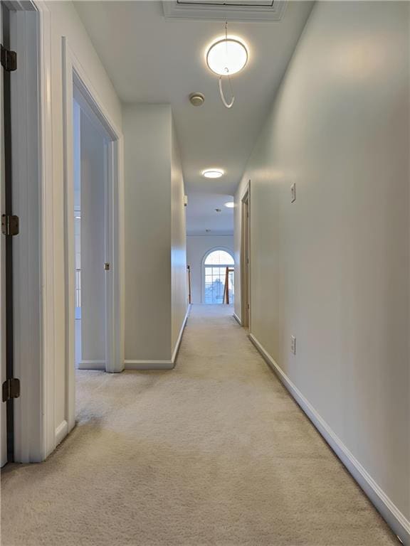 corridor featuring carpet floors, attic access, and baseboards