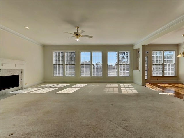 unfurnished living room with carpet floors, ornamental molding, a fireplace, and baseboards