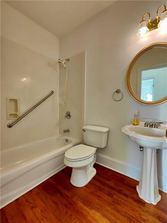 full bathroom with shower / bathtub combination, wood finished floors, toilet, and baseboards