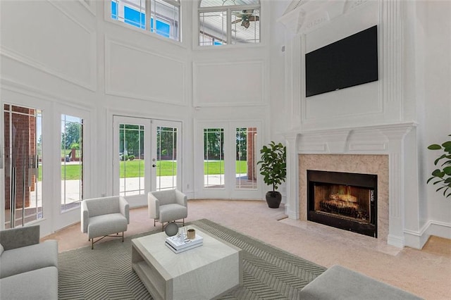 3030 Berry Rd, Loganville, GA 30052 - carpeted living room featuring a decorative wall, french doors, a high ceiling, healthy amount of natural light, and a high end fireplace