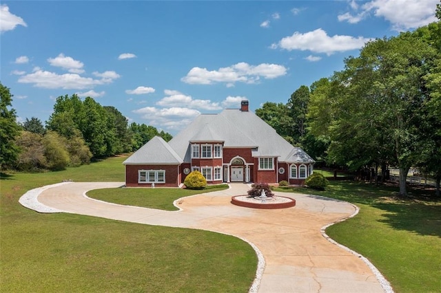 3030 Berry Rd, Loganville, GA 30052 - view of front of house featuring curved driveway, a front yard, brick siding, and a chimney