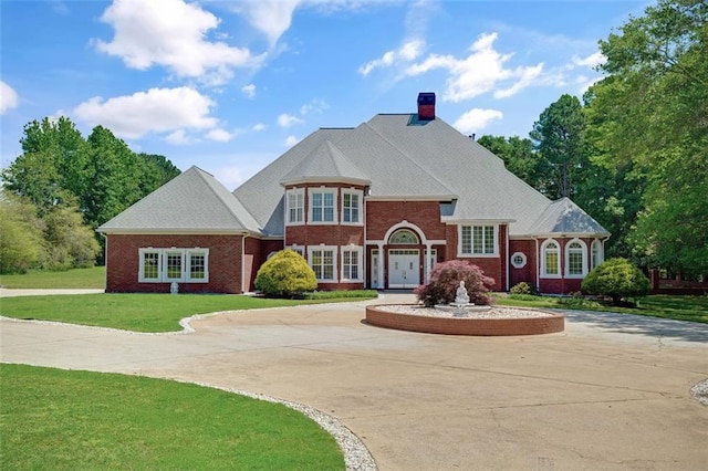 3030 Berry Rd, Loganville, GA 30052 - view of front facade with a front lawn, a chimney, brick siding, and curved driveway