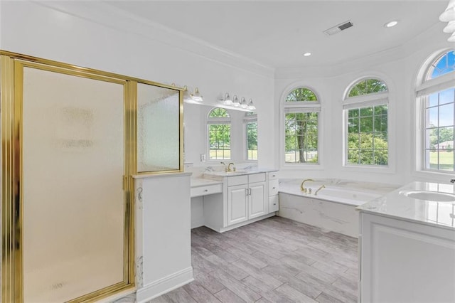 3030 Berry Rd, Loganville, GA 30052 - bathroom featuring a stall shower, two vanities, a garden tub, wood finished floors, and ornamental molding