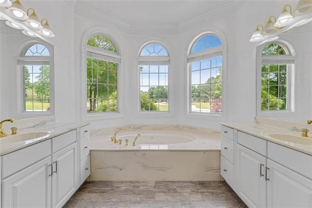 3030 Berry Rd, Loganville, GA 30052 - bathroom featuring two vanities, crown molding, and a garden tub