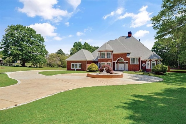3030 Berry Rd, Loganville, GA 30052 - view of front facade featuring curved driveway, a front yard, a chimney, and brick siding