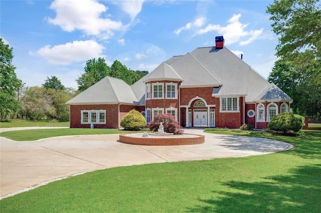 3030 Berry Rd, Loganville, GA 30052 - view of front facade featuring brick siding, a front yard, a chimney, and curved driveway