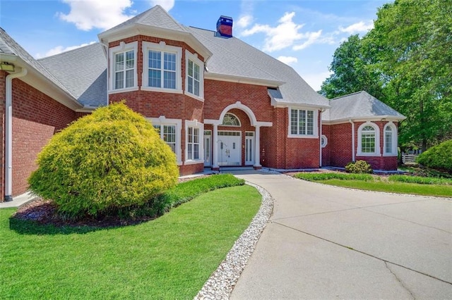 3030 Berry Rd, Loganville, GA 30052 - view of front of home with brick siding, a front yard, and a chimney
