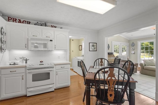 kitchen featuring ornamental molding, light hardwood / wood-style flooring, white appliances, white cabinetry, and backsplash