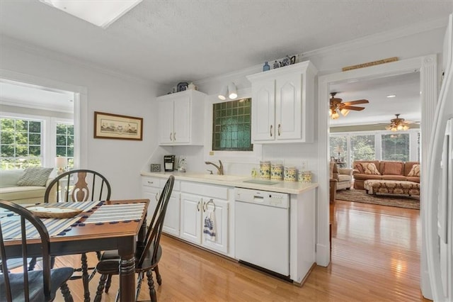 kitchen featuring white dishwasher, a healthy amount of sunlight, white cabinetry, and light wood-type flooring