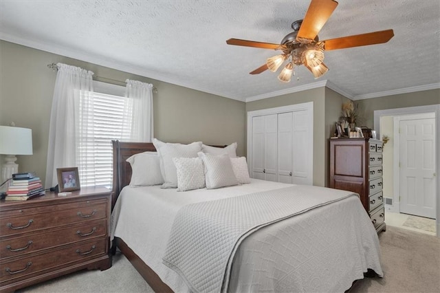 bedroom with a closet, a textured ceiling, ceiling fan, and light colored carpet