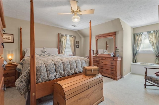 carpeted bedroom with a textured ceiling, ceiling fan, and vaulted ceiling