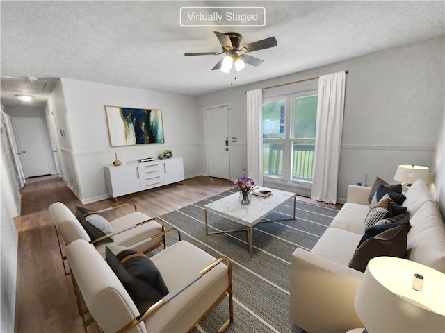 living room featuring a ceiling fan, baseboards, and wood finished floors