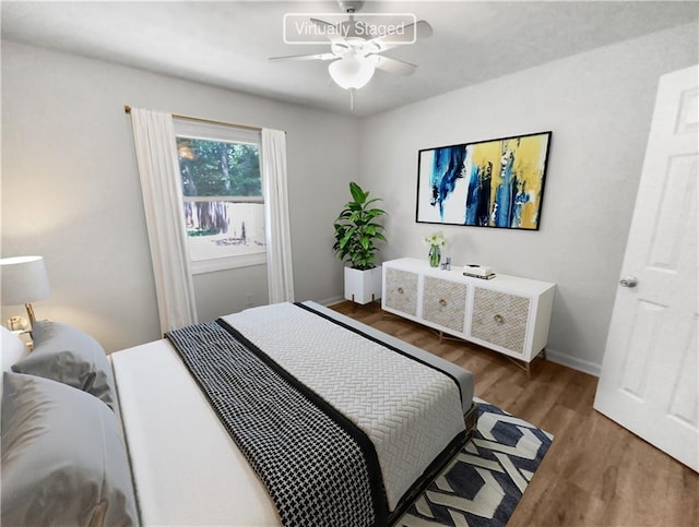 bedroom featuring wood finished floors, a ceiling fan, and baseboards