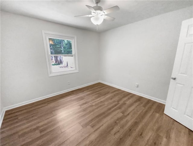 unfurnished room featuring ceiling fan, dark wood-style flooring, and baseboards