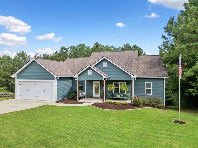 view of front of home with a garage, covered porch, and a front lawn