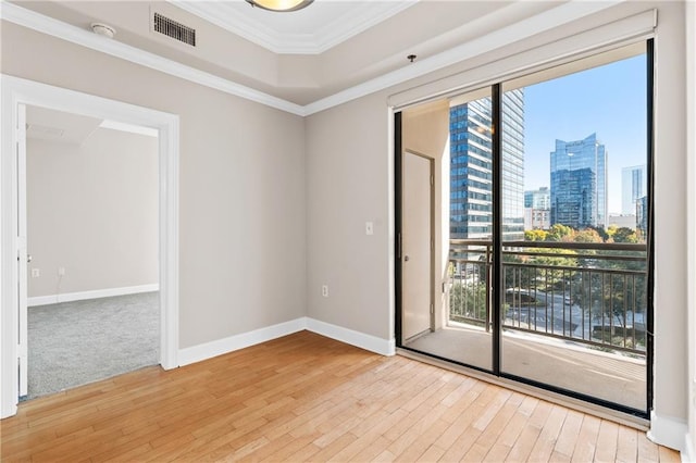 empty room with ornamental molding and light wood-type flooring