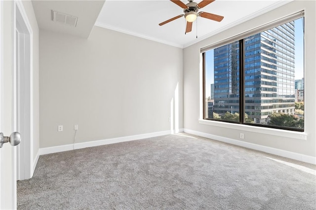 spare room featuring carpet flooring, ornamental molding, and ceiling fan