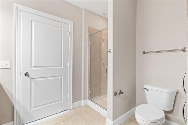 bathroom featuring toilet, tile patterned floors, and an enclosed shower