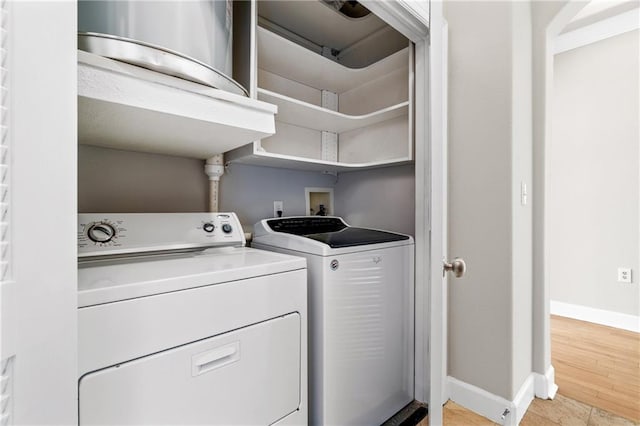 laundry room with light hardwood / wood-style floors and washer and clothes dryer