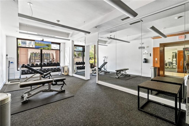 workout area with a tray ceiling