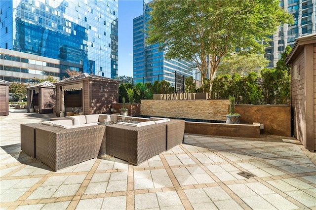 view of patio with an outdoor living space with a fire pit