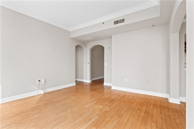 empty room with ornamental molding and light wood-type flooring