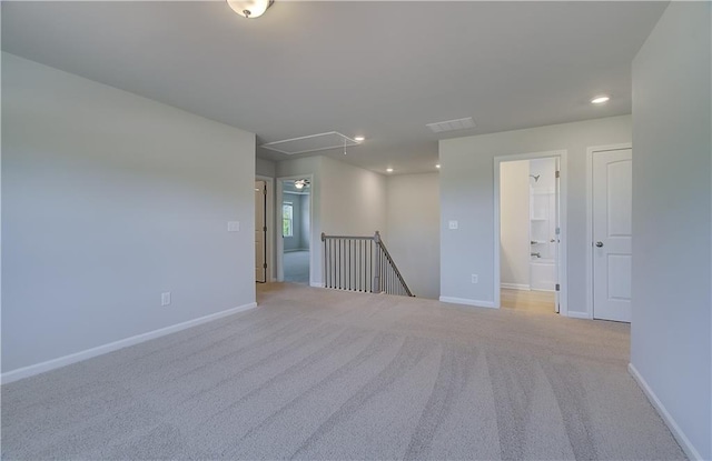 empty room with attic access, carpet, baseboards, and recessed lighting