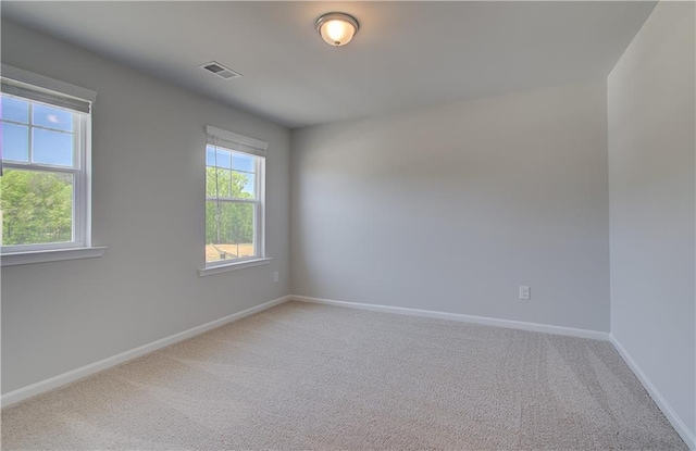 unfurnished room featuring light colored carpet and baseboards