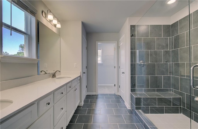 full bath with a shower stall, tile patterned flooring, double vanity, baseboards, and a spacious closet