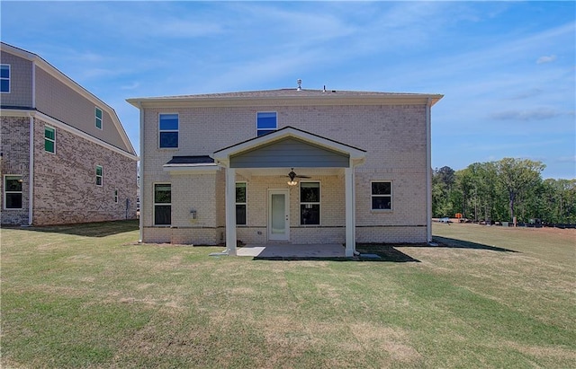 rear view of property with a ceiling fan, a patio area, a yard, and brick siding