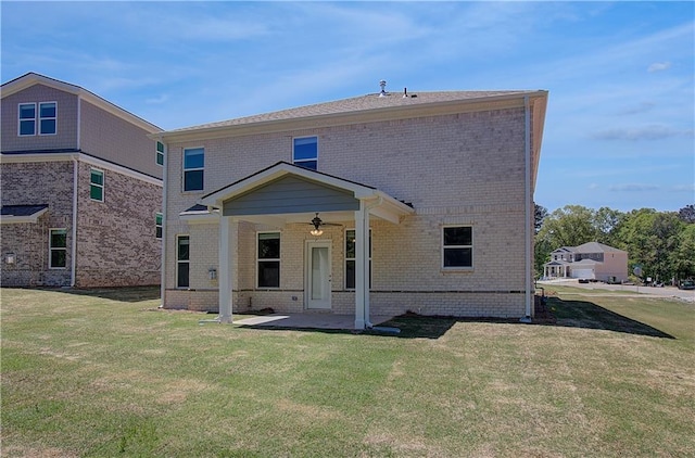 back of property featuring a patio, a lawn, a ceiling fan, and brick siding