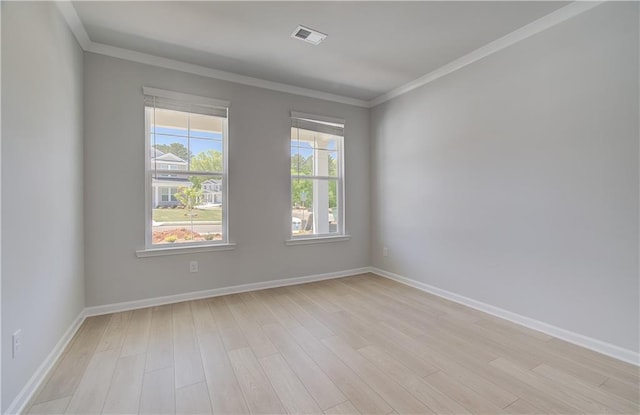 unfurnished room with light wood-style flooring, crown molding, and baseboards