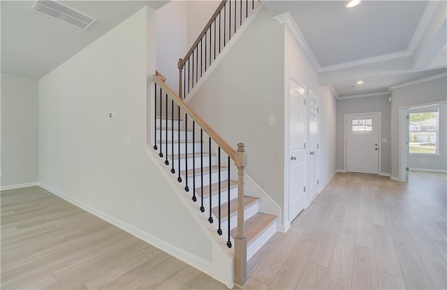 foyer featuring crown molding, light wood-style flooring, baseboards, stairs, and recessed lighting