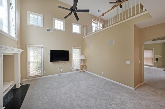 2747 Harper Woods Dr, Marietta, GA 30062 - unfurnished living room with a ceiling fan, a towering ceiling, carpet, arched walkways, and baseboards