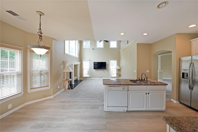 2747 Harper Woods Dr, Marietta, GA 30062 - kitchen with white dishwasher, a sink, stainless steel fridge, arched walkways, and a fireplace