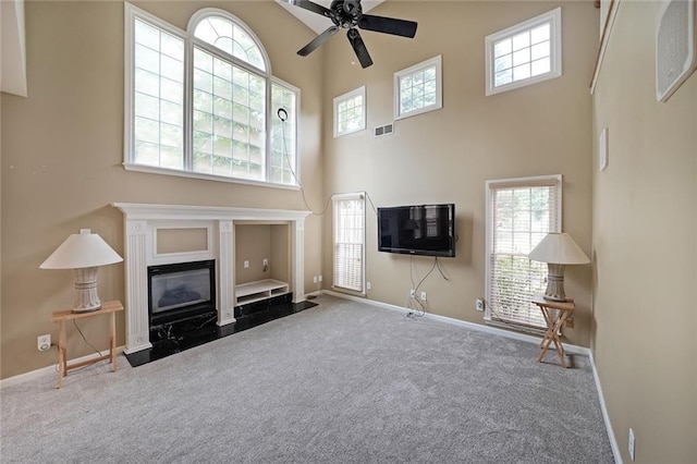 2747 Harper Woods Dr, Marietta, GA 30062 - carpeted living room featuring a towering ceiling, baseboards, a ceiling fan, healthy amount of natural light, and a fireplace with flush hearth