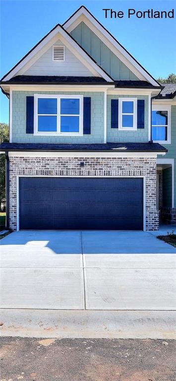 view of front facade featuring a garage, brick siding, and driveway