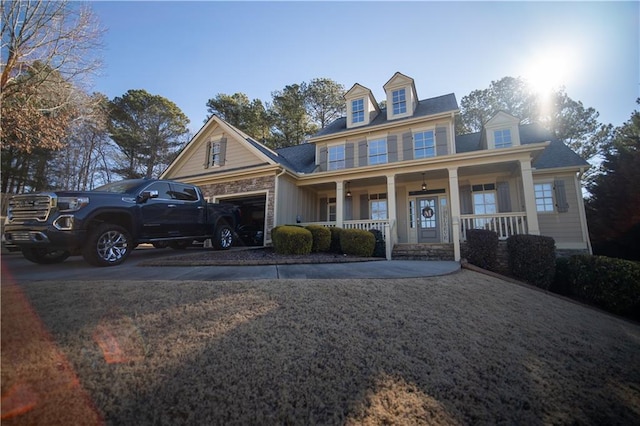 new england style home featuring a garage and covered porch