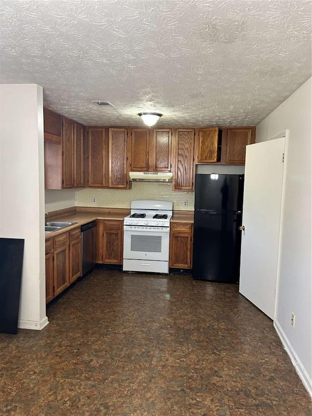 kitchen featuring brown cabinets, freestanding refrigerator, white gas range, under cabinet range hood, and stainless steel dishwasher